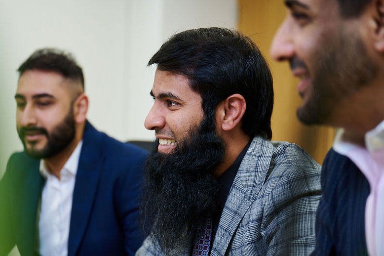 Man with beard smiling during meeting