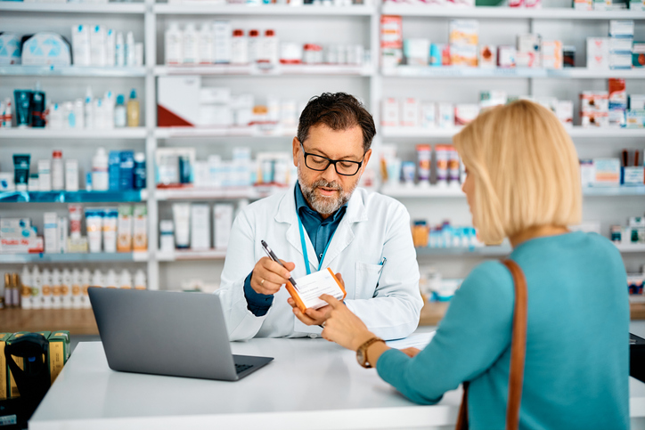 Pharmacist advising female customer who is buying prescription medicine in a pharmacy.