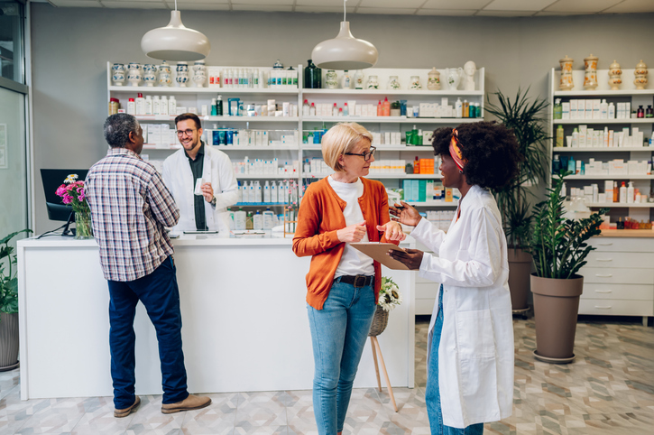 Female pharmacist talking to a senior customer in a pharmacy