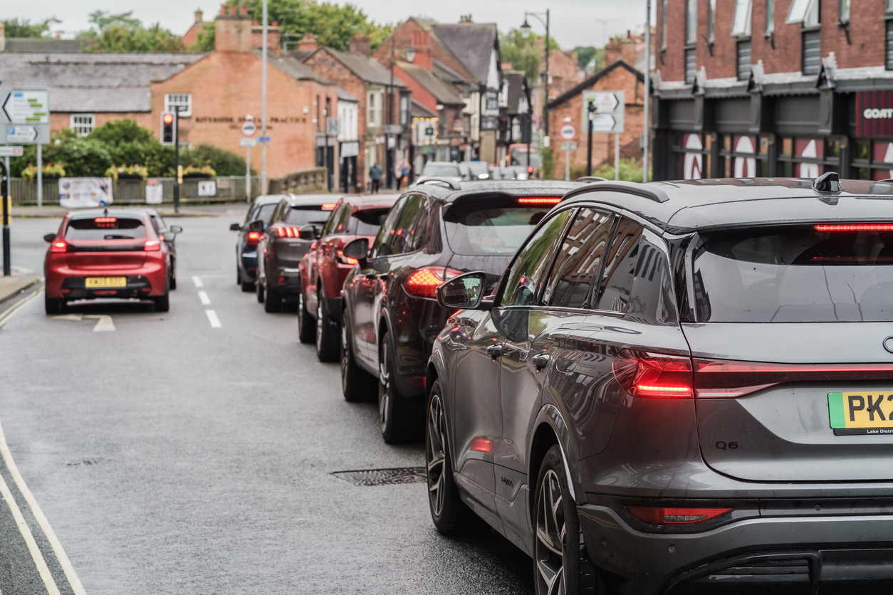 A row of cars are waiting at a traffic light