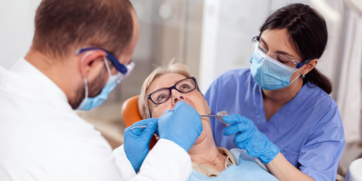 Dentist and dental nurse treating a patient during a dental practice appointment"